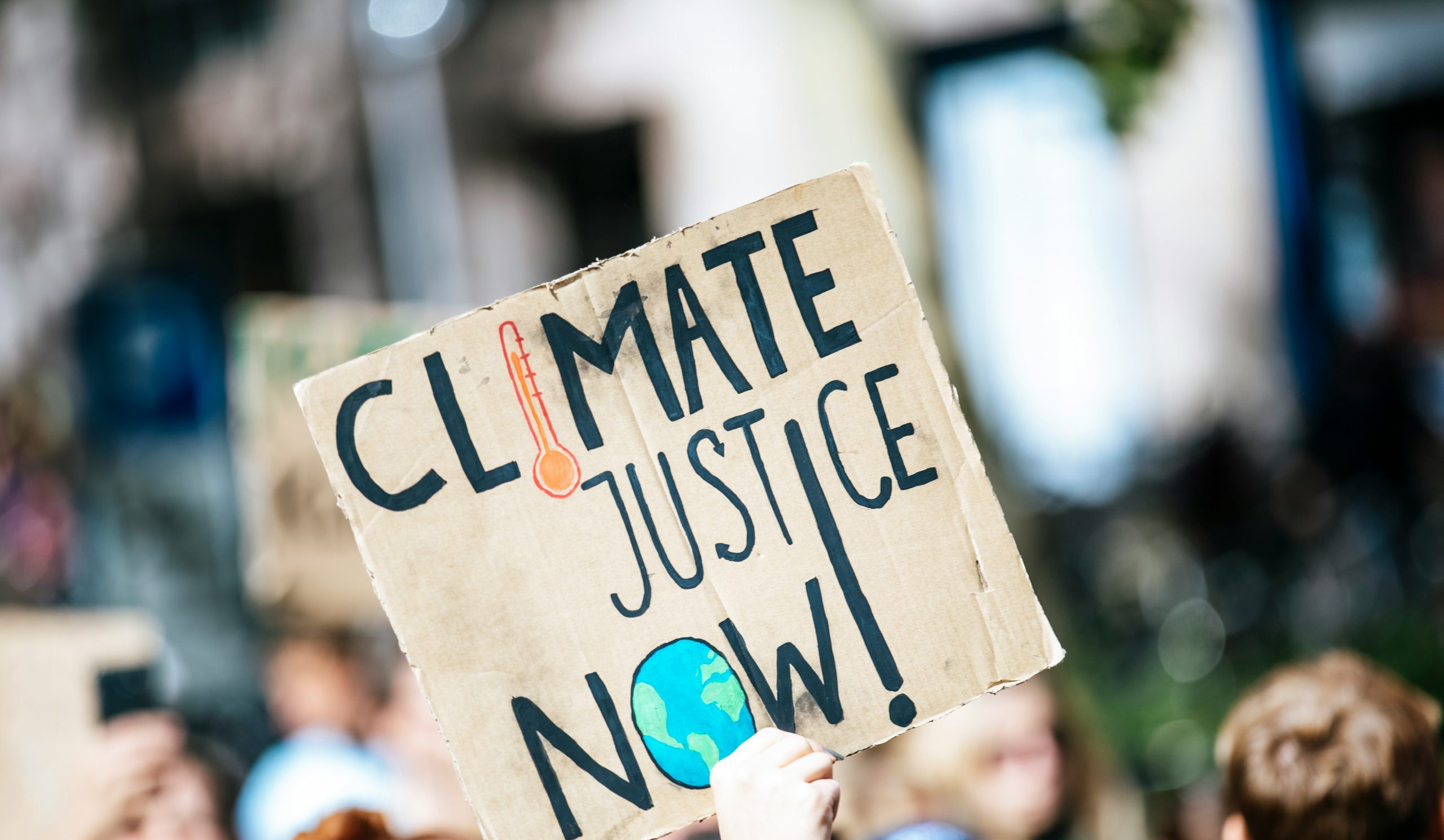 Sign reading 'climate justice now'